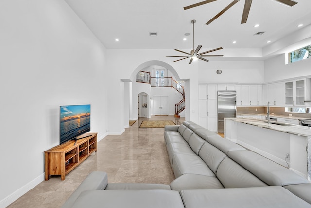 living room with sink, a towering ceiling, and ceiling fan