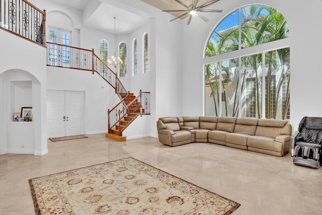 living room featuring a towering ceiling, a notable chandelier, and plenty of natural light