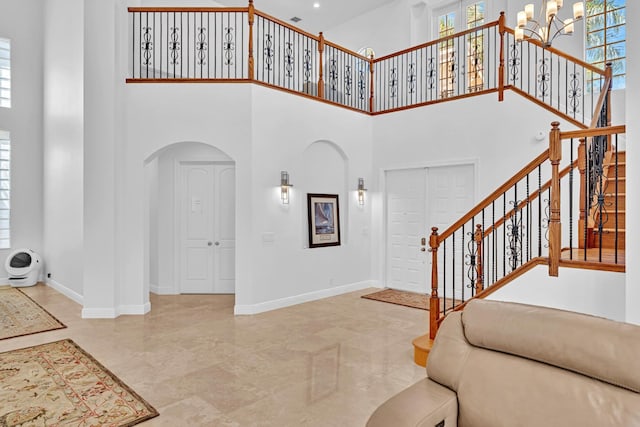 foyer featuring an inviting chandelier and a high ceiling