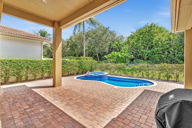 view of swimming pool with a patio, an in ground hot tub, and grilling area