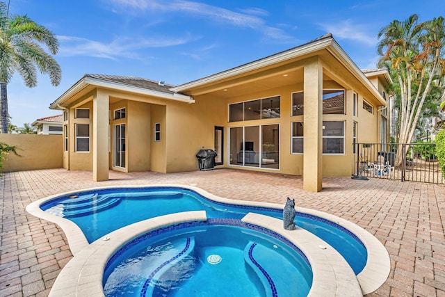 back of house with a patio and a swimming pool with hot tub