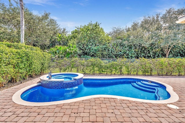 view of pool with an in ground hot tub and a patio