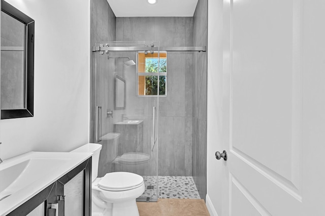 bathroom featuring toilet, an enclosed shower, vanity, and tile patterned flooring