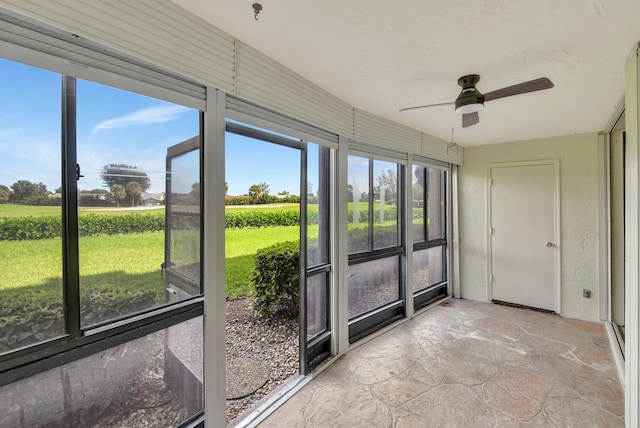 unfurnished sunroom featuring ceiling fan