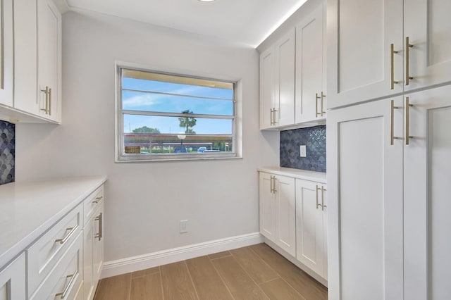 kitchen featuring decorative backsplash, white cabinets, and light hardwood / wood-style floors