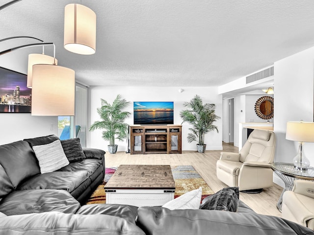 living room with light wood-type flooring and a textured ceiling