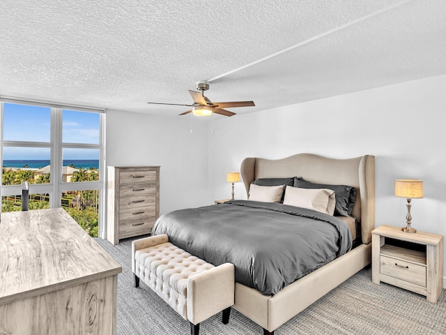 2200 S Ocean Blvd Unit 806, Delray Beach, FL 33483 - bedroom with carpet floors, a water view, a textured ceiling, and ceiling fan