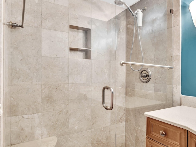 bathroom featuring vanity and a shower with door