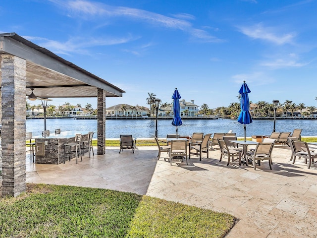 view of patio featuring exterior bar and a water view