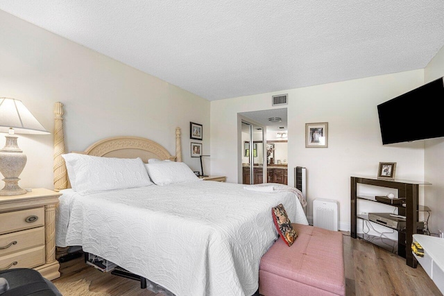 bedroom featuring hardwood / wood-style flooring and a textured ceiling