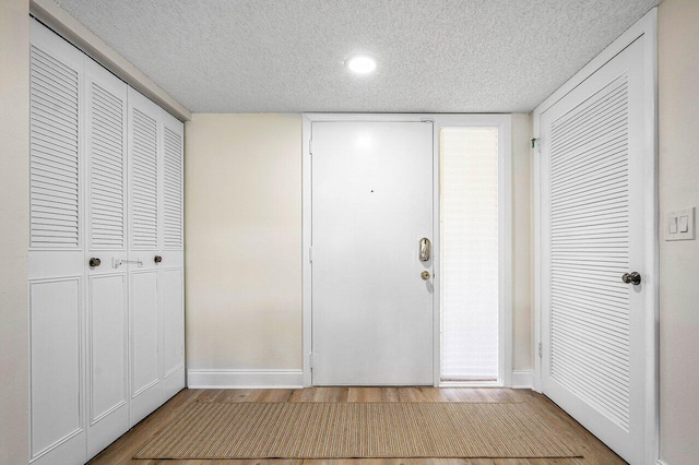 entrance foyer featuring light hardwood / wood-style floors and a textured ceiling