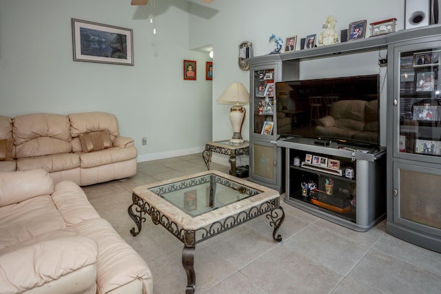 living room with light tile patterned floors, a ceiling fan, and baseboards