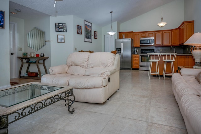 living room with high vaulted ceiling and light tile patterned flooring