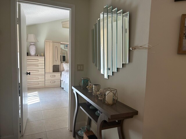 hallway featuring light tile patterned flooring and a textured ceiling