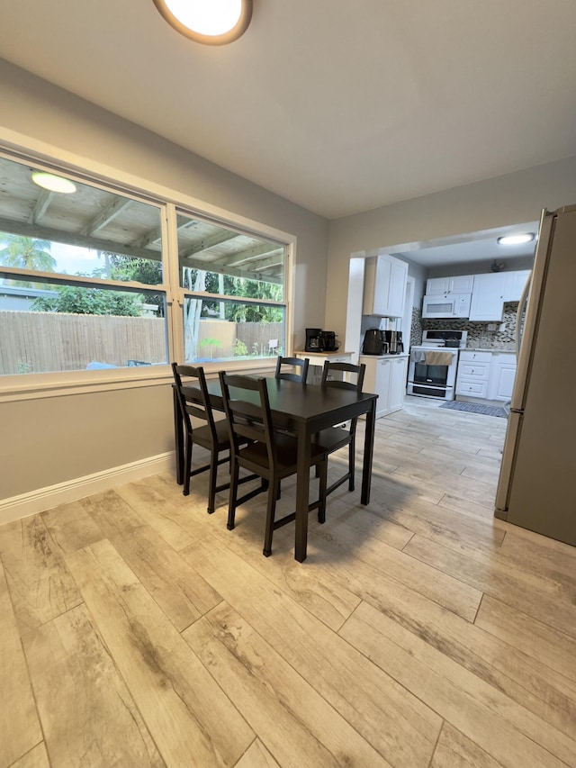 dining room with light wood-type flooring and baseboards