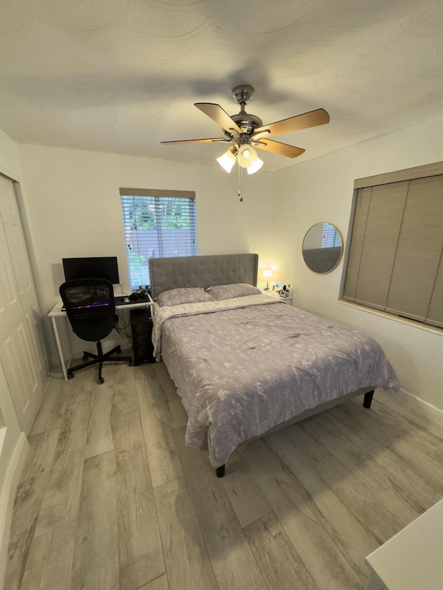 bedroom with light wood-style flooring and a ceiling fan