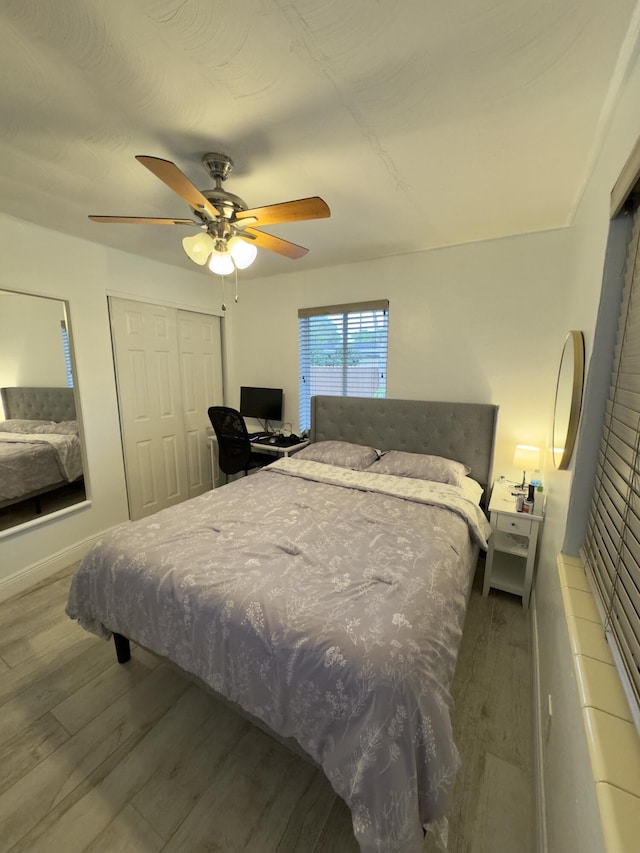 bedroom with a closet, wood finished floors, and a ceiling fan