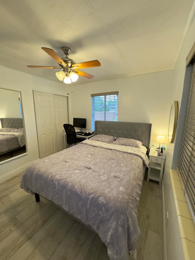 bedroom featuring hardwood / wood-style flooring, a closet, and ceiling fan