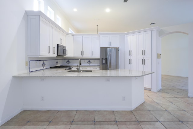 kitchen featuring kitchen peninsula, white cabinetry, and appliances with stainless steel finishes