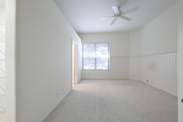 spare room with ceiling fan and light colored carpet