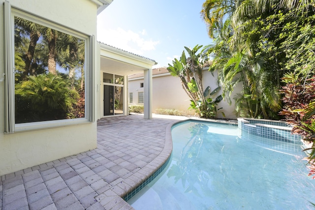 view of swimming pool featuring an in ground hot tub and a patio