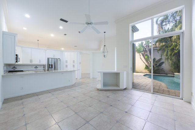 kitchen featuring light stone countertops, appliances with stainless steel finishes, ceiling fan, crown molding, and white cabinetry