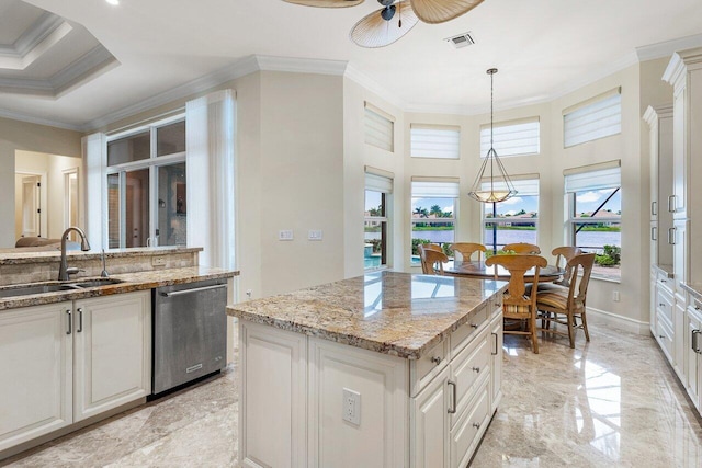 kitchen featuring crown molding, sink, stainless steel dishwasher, decorative light fixtures, and a kitchen island