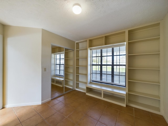 interior space with built in features, a textured ceiling, and baseboards