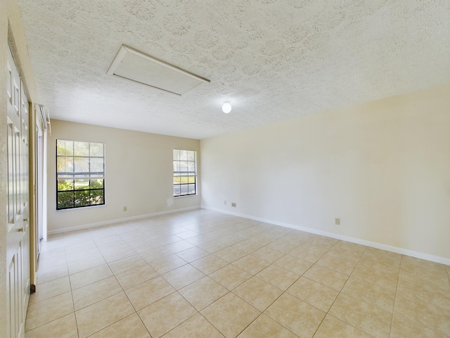 tiled spare room featuring a textured ceiling