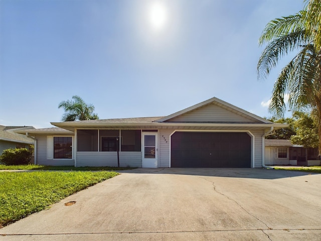 single story home featuring a garage, concrete driveway, and a front lawn