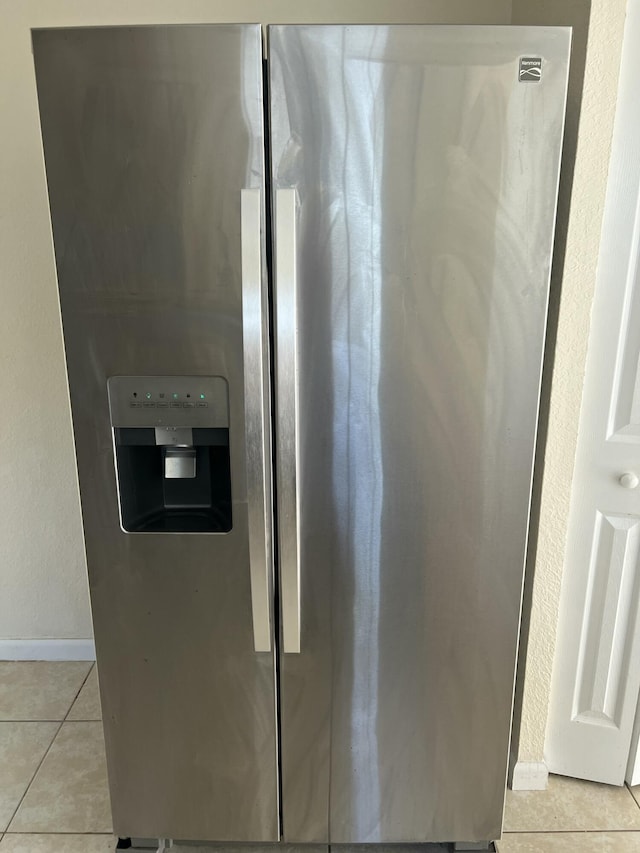 interior details with stainless steel refrigerator with ice dispenser and baseboards