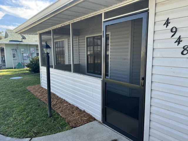 doorway to property with a lawn