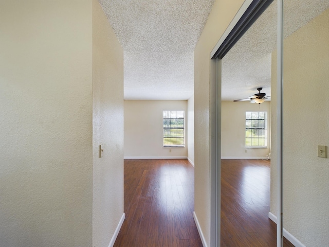 4948 SE 44th St, Okeechobee, FL 34974 - hall with dark wood-type flooring, plenty of natural light, a textured ceiling, a textured wall, and baseboards