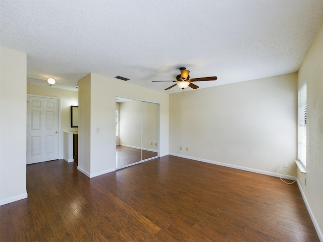 unfurnished room featuring visible vents, a textured ceiling, baseboards, and wood finished floors