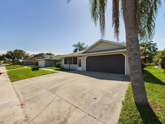 ranch-style house with a garage and a front lawn