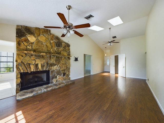 4948 SE 44th St, Okeechobee, FL 34974 - unfurnished living room featuring ceiling fan, wood finished floors, a skylight, high vaulted ceiling, and a stone fireplace