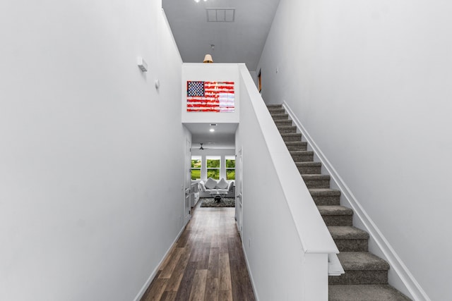 stairs with a high ceiling and hardwood / wood-style flooring