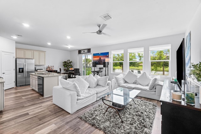 living room with light hardwood / wood-style flooring and ceiling fan