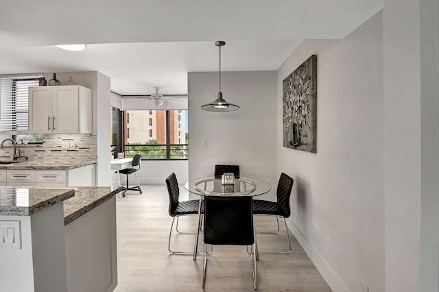 dining area featuring sink and ceiling fan