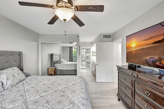 bedroom with a closet, connected bathroom, light wood-type flooring, and ceiling fan