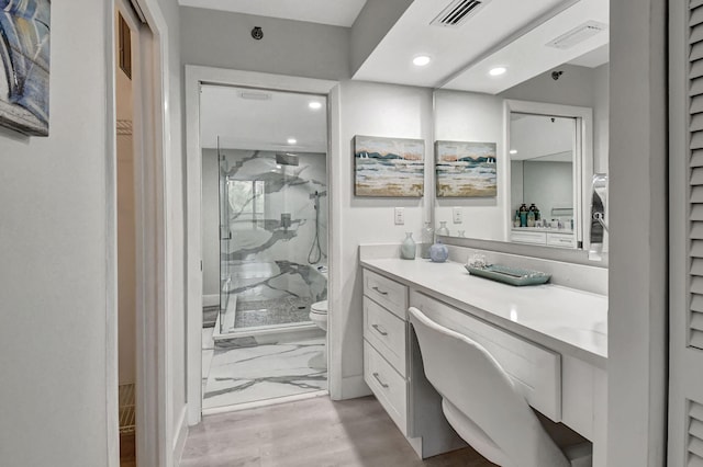 bathroom featuring walk in shower, hardwood / wood-style floors, vanity, and toilet