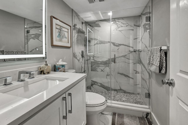 bathroom with vanity, toilet, and a shower with shower door