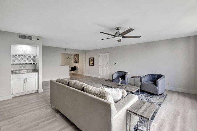 living room featuring light wood-type flooring and ceiling fan