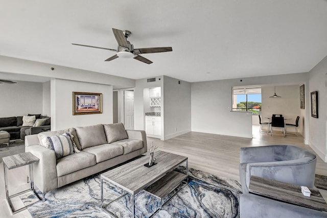 living room featuring light wood-type flooring and ceiling fan