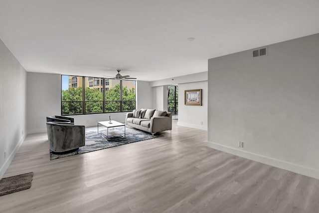 unfurnished living room with ceiling fan, light wood-type flooring, and a wealth of natural light