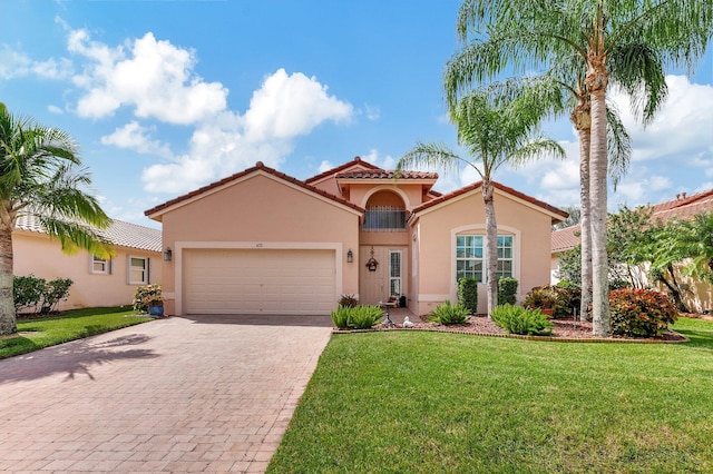 mediterranean / spanish-style house featuring a front yard and a garage