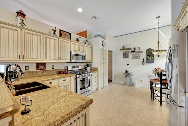 kitchen featuring hanging light fixtures, light tile patterned floors, stainless steel appliances, sink, and light stone counters