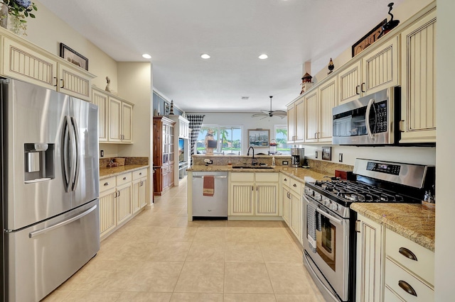 kitchen with sink, cream cabinetry, kitchen peninsula, and stainless steel appliances