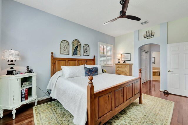 bedroom featuring ensuite bathroom, hardwood / wood-style flooring, a closet, and ceiling fan