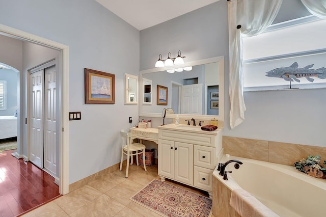 bathroom featuring vanity, hardwood / wood-style floors, and a washtub